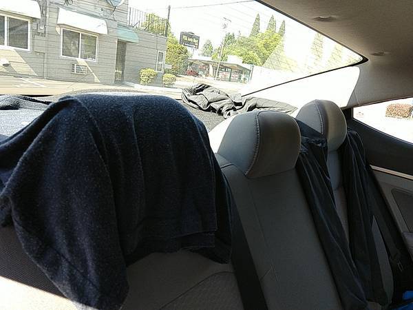 clothes hanging under rear window of a car